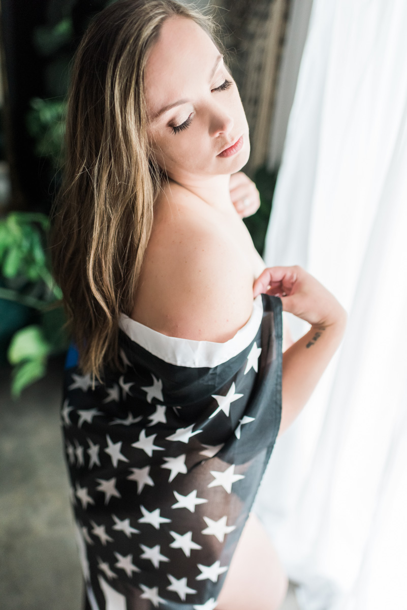 A woman elegantly draped in a black and white American flag wrap, showcasing a blend of patriotism and style.